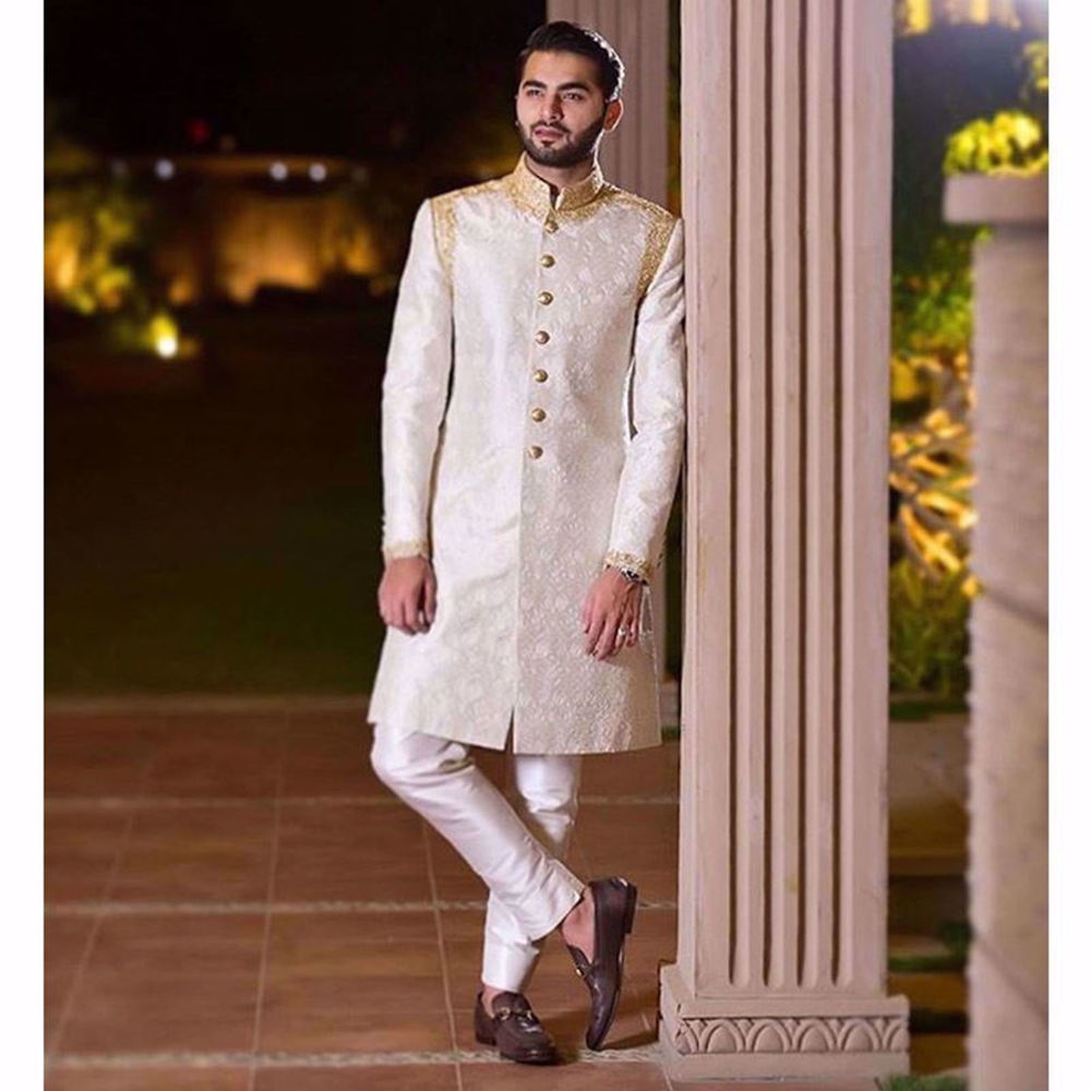 Picture of SHEHROZE HANIF IN A WHITE ON WHITE EMBROIDERED CLASSIC TAILORED SHERWANI WITH GOLD ZARDOZI COLLAR