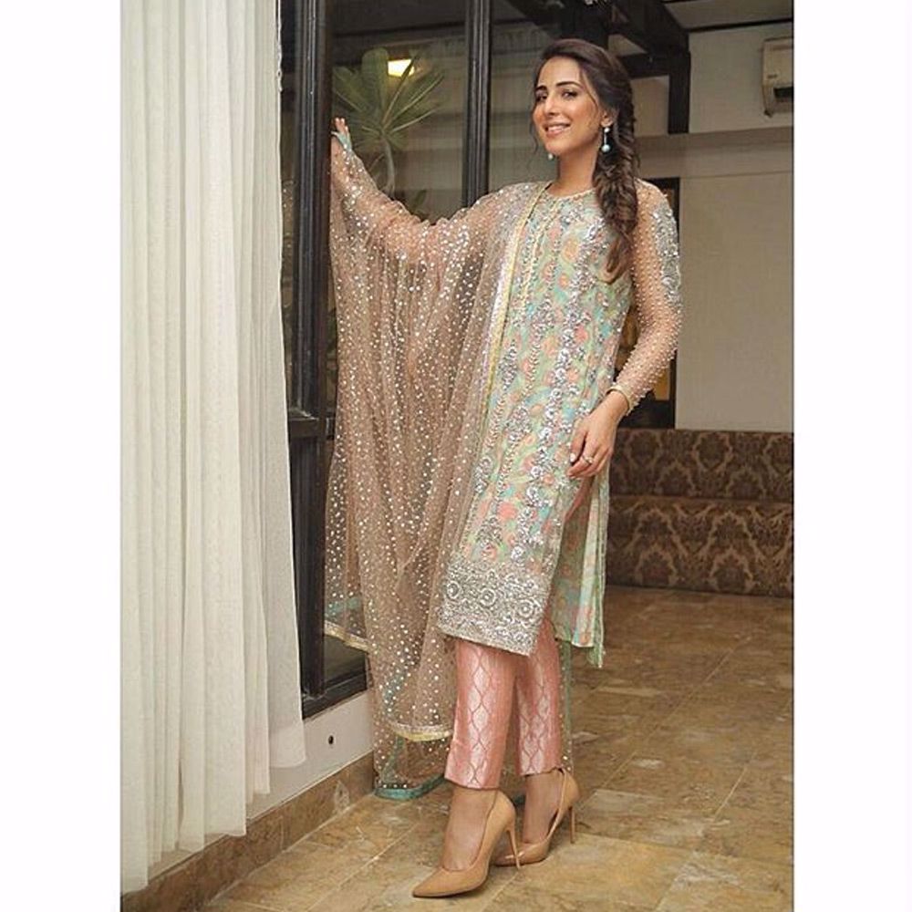 Picture of Ushna Shah wears our powder pink tulle net embroidered shirt paired with a peach tulle net dupatta and brocade pants.