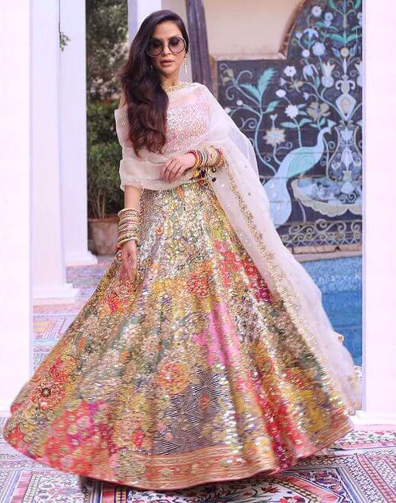Picture of A multi-hued print with the most dazzling mirrorwork and hand detailing, paired with a pink mirror-worked choli and minimal ivory scalloped dupatta