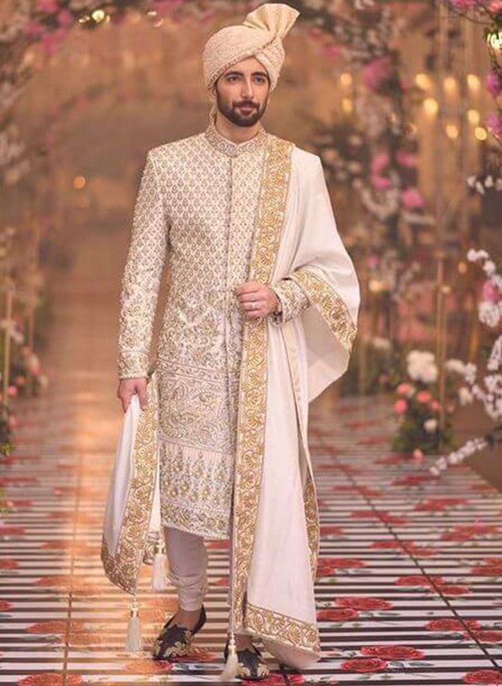 A richly worked gold and silver handworked sherwani finished with an embroidered shawl and turban for Ali s grand look Nomi Ansari