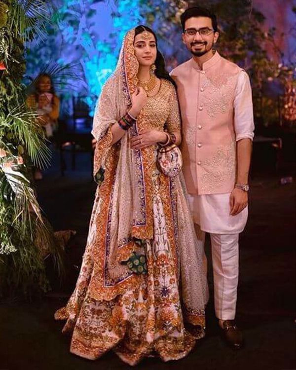 Picture of A soft gold choli paired with our signature print and handworked lehnga, plus a detailed bordered dupatta in ivory for Zarmina’s classy bridal look