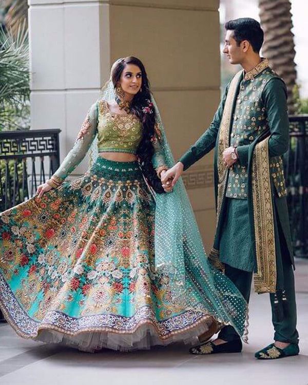 Picture of Amir Dawood in an embroidered kurta, embellished waistcoat and banarsi bordered shawl. Coordinating in a royal look is Ameera in